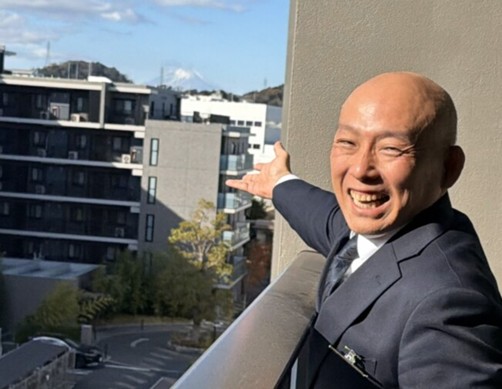 ホームの5階から見える富士山と上席ホーム長の猿渡さん